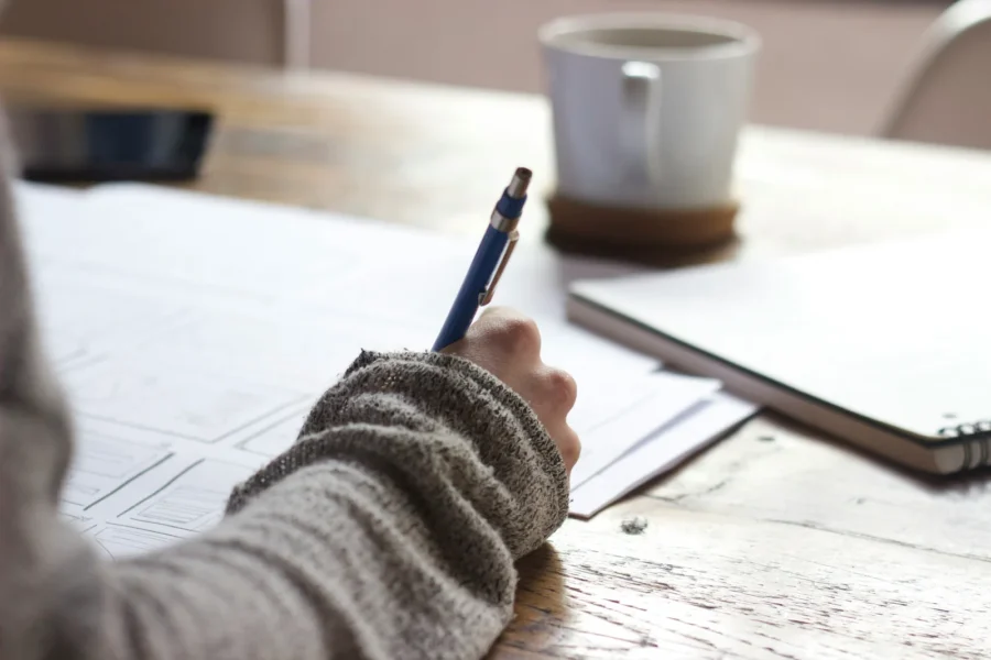 Escritorio de estudio con portátil y apuntes para preparar oposiciones